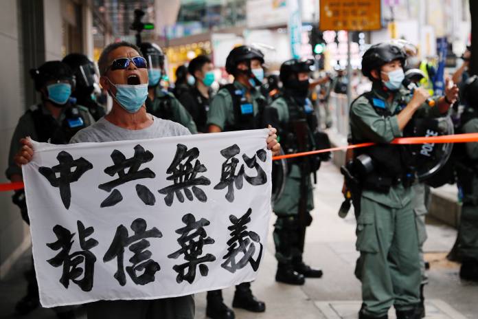 An anti-national security law protester holds a banner reading